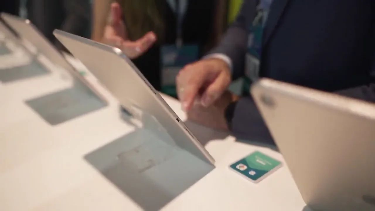 Visitantes usando tablets em uma bancada de demonstração