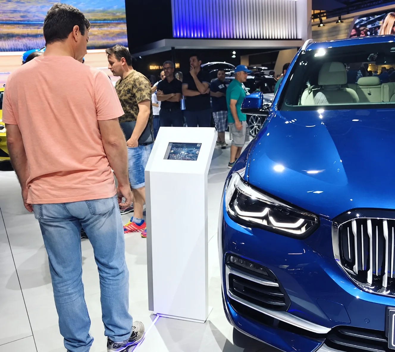 Visitantes junto ao totem com tablet no Salão do Automóvel