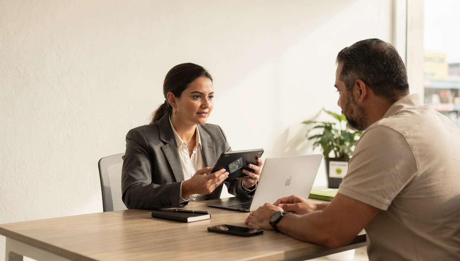 Representante comercial apresenta uma proposta em tablet durante uma visita ao cliente